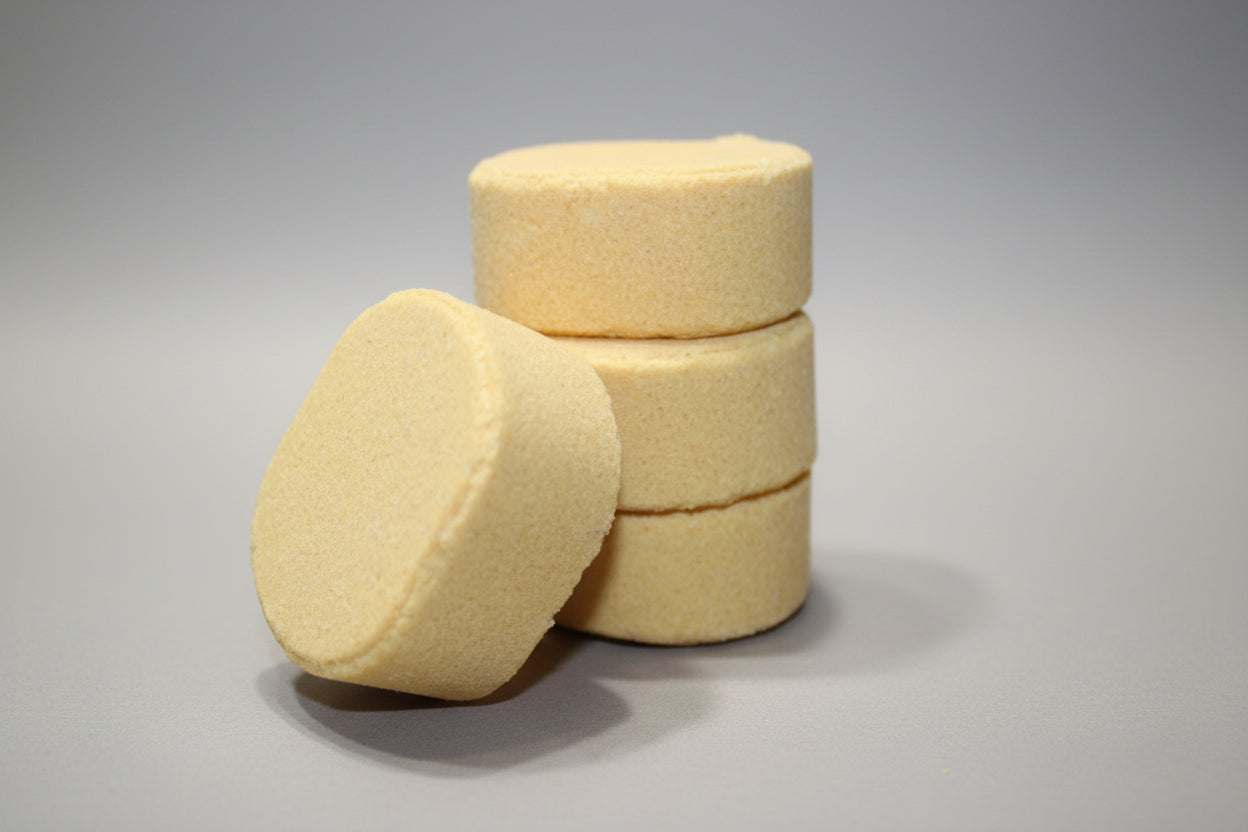 Three yellow circular objects stacked on a textured surface with a neutral background