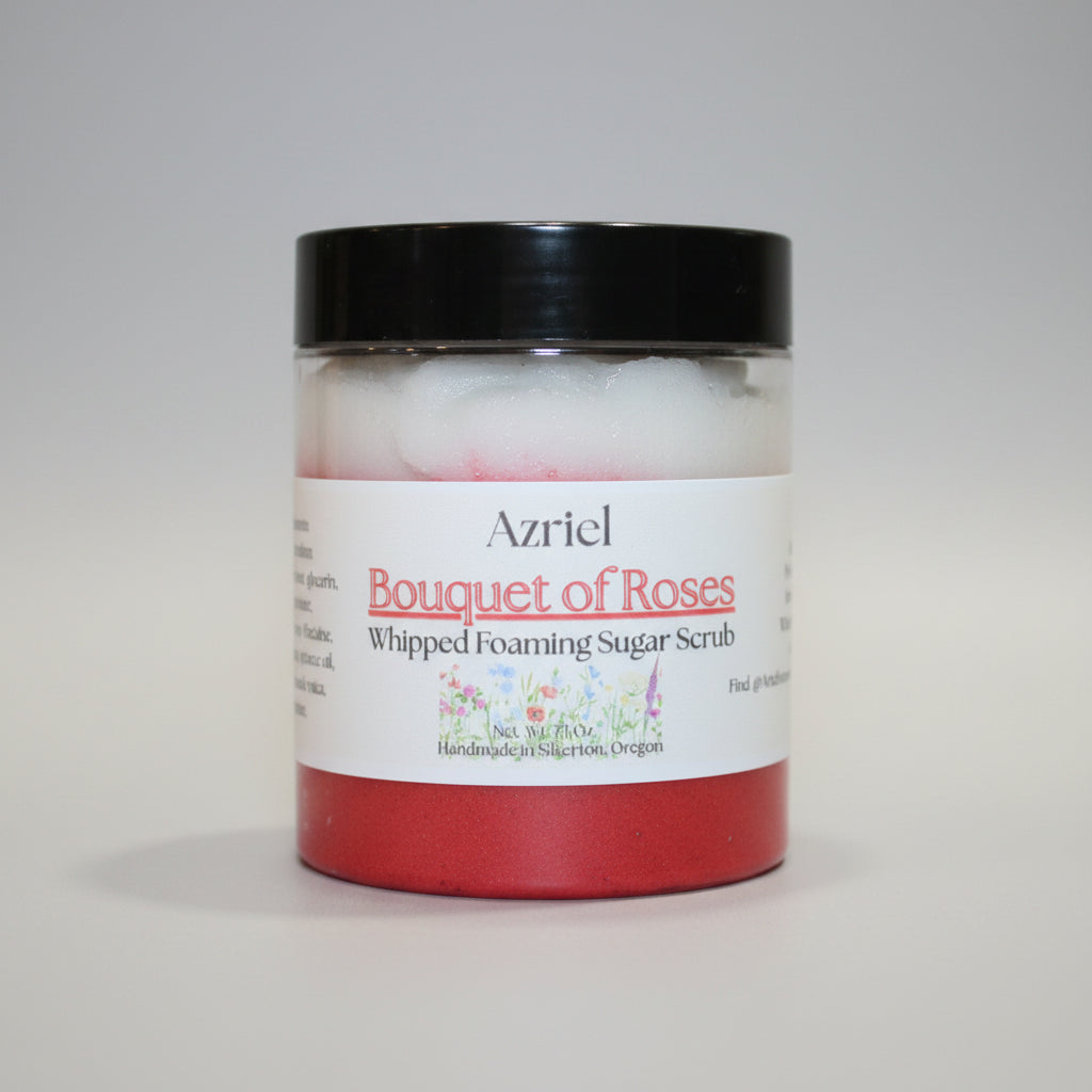 Jar of 'Bouquet of Roses' whipped foaming sugar scrub with a black lid on a beige background