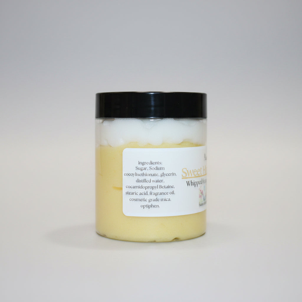 Jar of whipped body butter with a label on a beige background