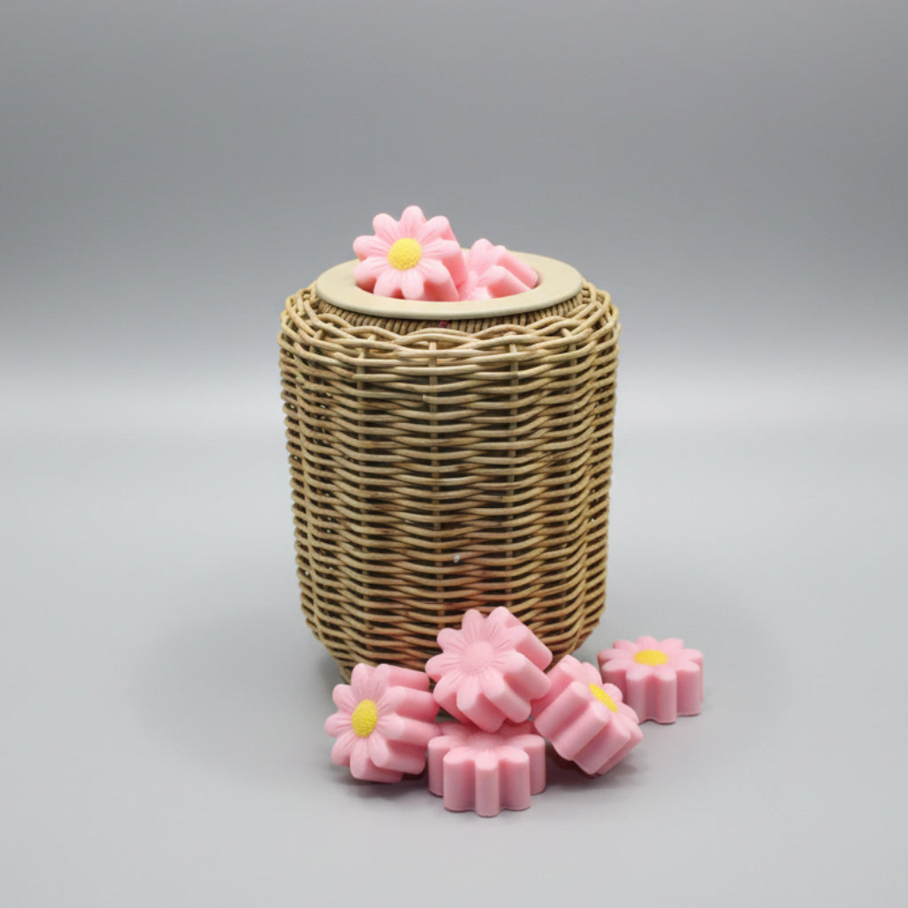 Wicker basket with pink flower-shaped soap bars on a bathroom floor.