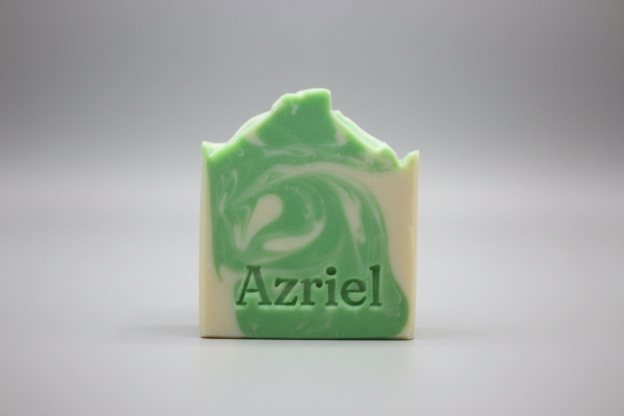 Green and white swirled soap bar with 'Azriel' branding on a wooden surface.