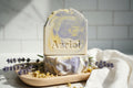Decorative soap bar with 'Azriel' branding on a wooden surface