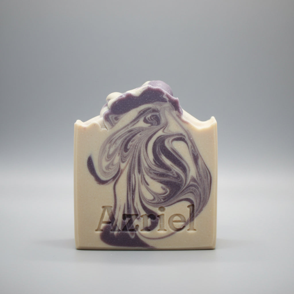Marbled purple and white soap bar with 'Azzed' branding on a beige surface.