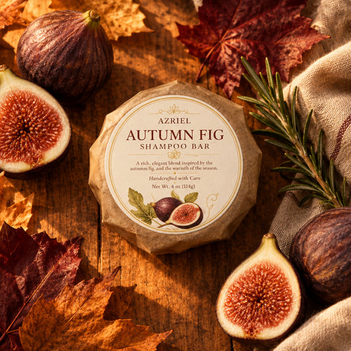 A round handmade shampoo bar wrapped in brown kraft paper with a white circular label reading 'AZRIEL AUTUMNFIG SHAMPOO BAR' and showing fig illustrations, placed on a wooden surface.